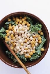 Finished salad in a large salad bowl with a wooden spoon