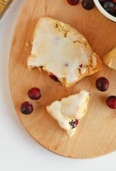 Cranberry Orange Scones broken in half next to fresh cranberries