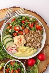 Finished dish in a white bowl on a wooden platter