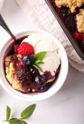 Homemade cobbler in a white bowl with ice cream