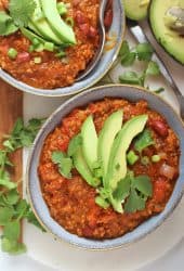 Two bowls of vegan chili with avocado and cilantro