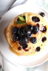 Overhead shot of blueberry pancakes on a white plate