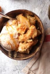 Finished apple cobbler in a brown bowl with ice cream