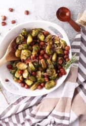 Roasted brussels sprouts and hazelnuts in a white bowl