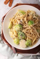 Finished Alfredo pasta in a white plate with a fork