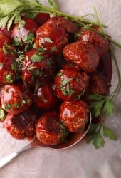 Finished vegan meatballs on a silver platter with a serving spoon