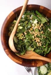 Finished salad in a wooden salad bowl with tongs