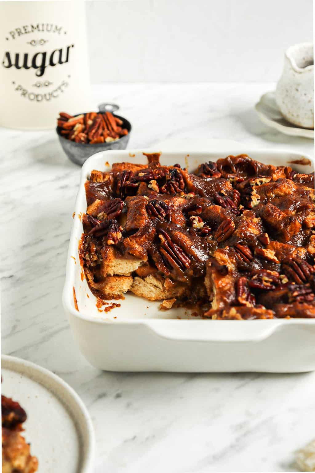 one pan of baked vegan bread pudding with slice taken out of it