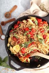 Finished pasta in a cast iron skillet with a wooden spoon