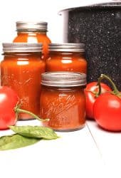 Canned tomato sauce next to canner