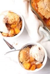 Two bowls of finished cobbler with vanilla ice cream